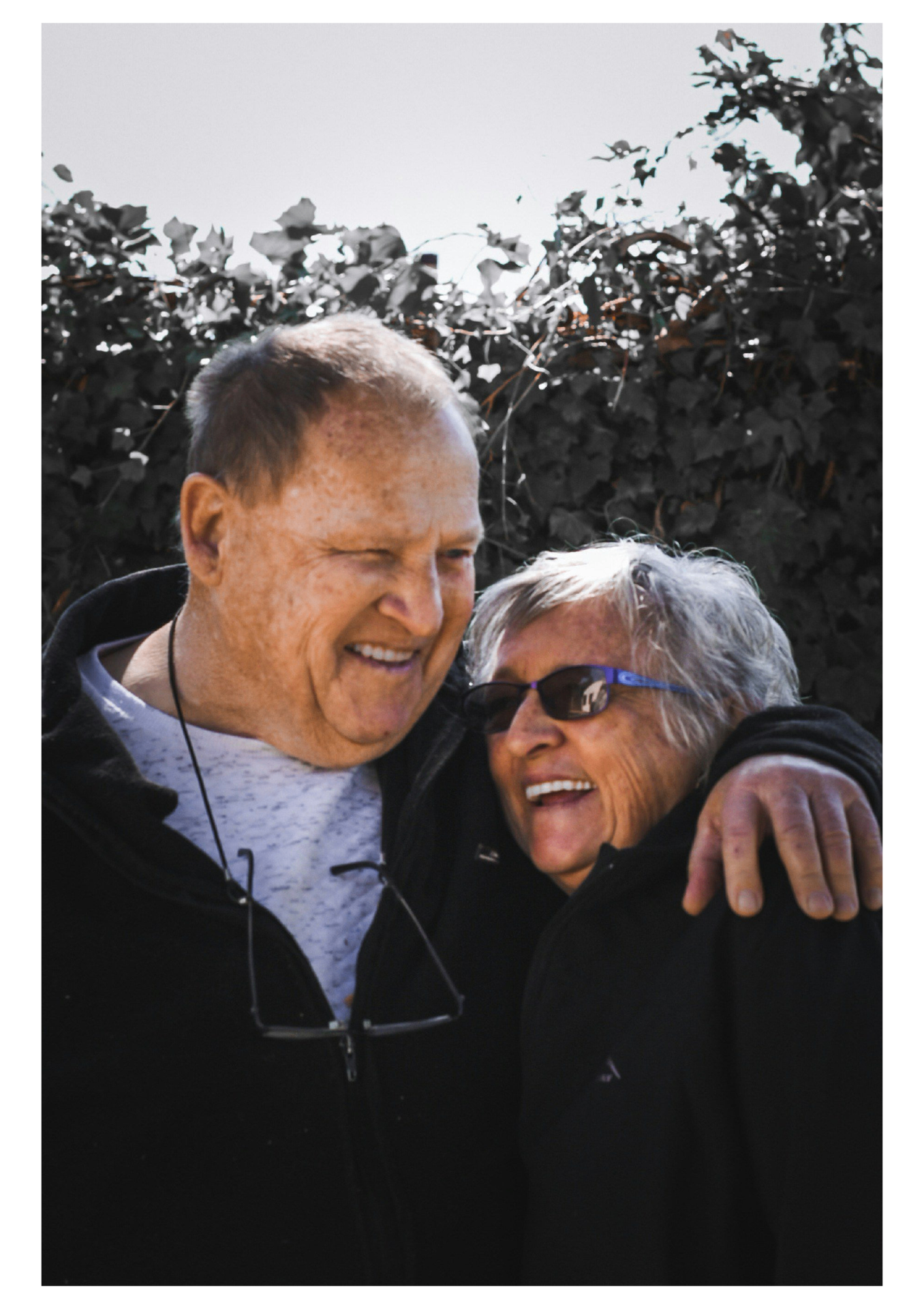 Two older friends sharing a warm laugh together outdoors